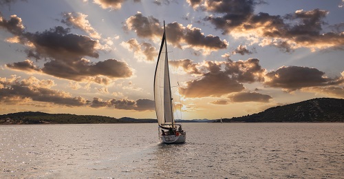 Segelboot segelt dem Sonnenuntergang entgegen